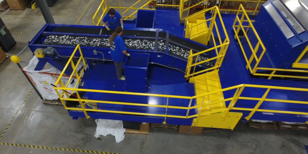 Arial shot of employees separating materials on the end of the recycling machine